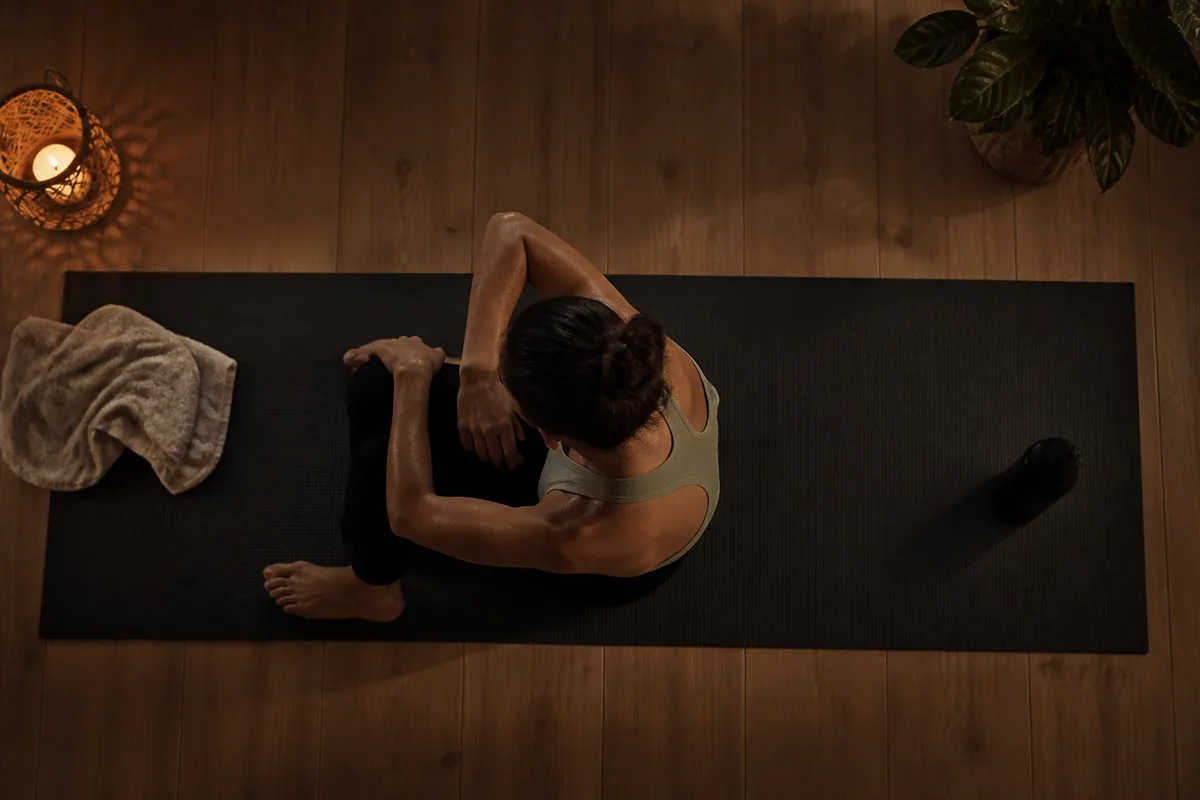 Un pratiquant récupère assis sur un tapis, la respiration revenant au calme
